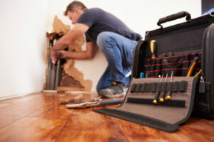 Plumber repairing burst water pipe